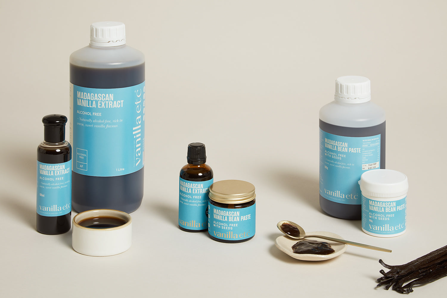 Collection of vanilla extract bottles and related products on a neutral background
