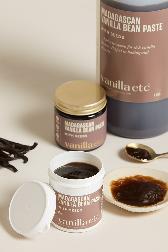 Bottle, jar  and tub of Vanilla bean paste with open container and silver spoon showing consistency
