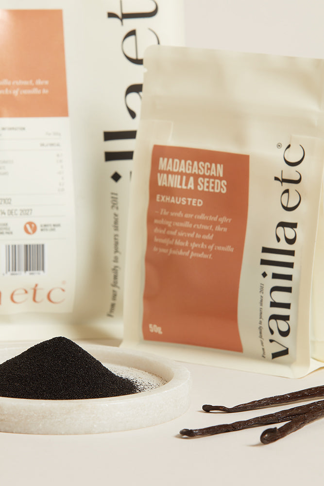 Vanilla seeds packaging with vanilla beans and seeds on a white surface
