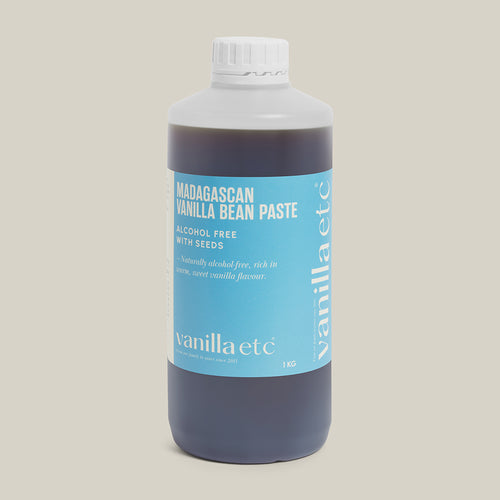 Bottle of Madagascan Vanilla Bean Paste with a blue label on a beige background